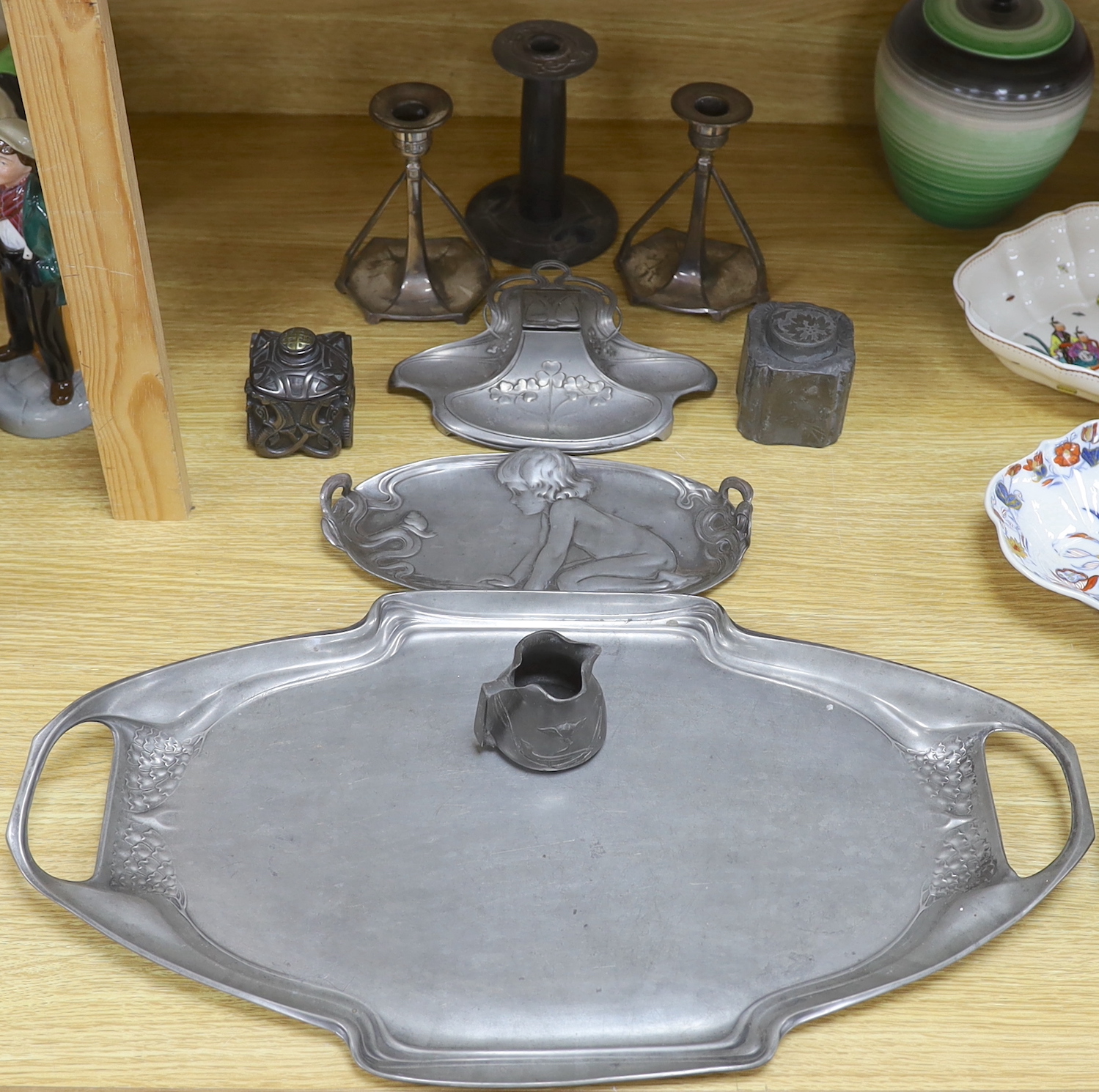 Art Nouveau pewter consisting:- an Orivit two handled tray, pattern 2967, a pair of candlesticks, a single enamel candlestick, a small tray embossed with an infant girl, a WMF inkstand and three other items (9), tray 54c
